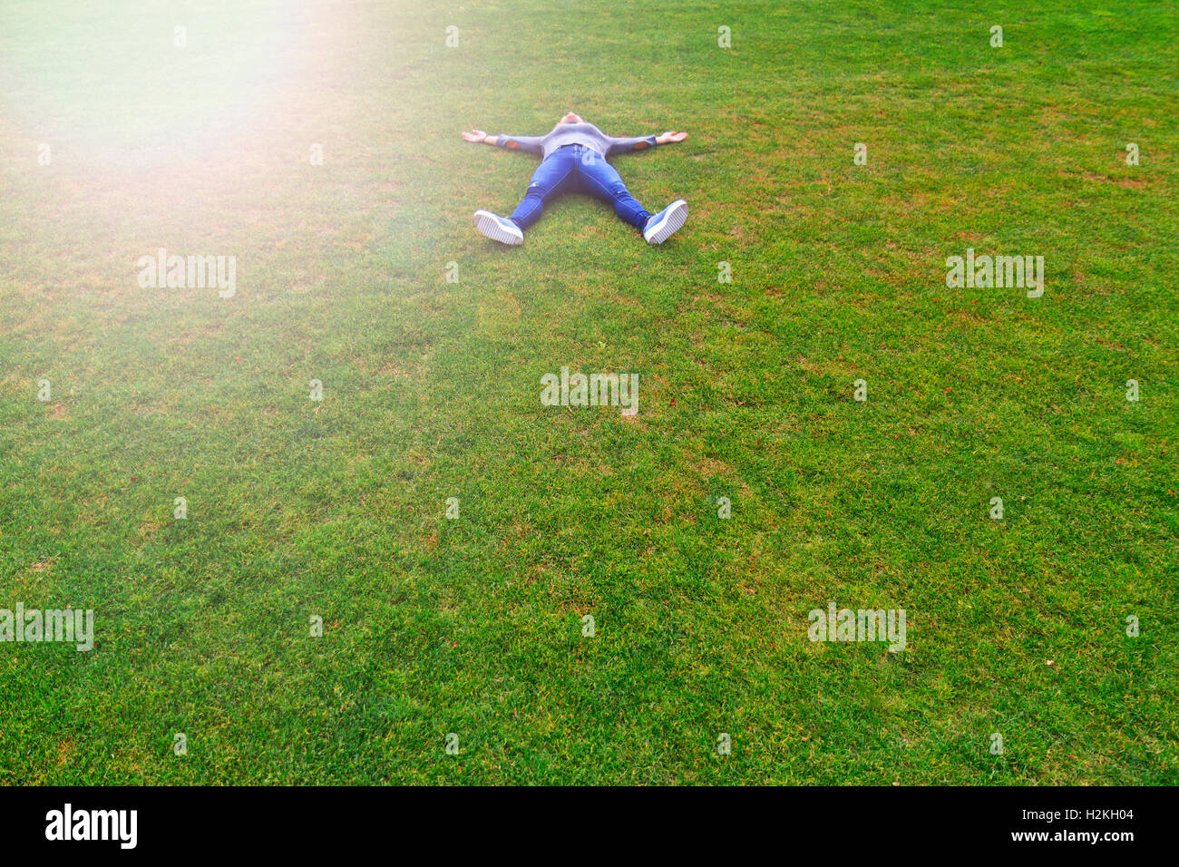 blonde girl reclined on a green lawn Stock Photo