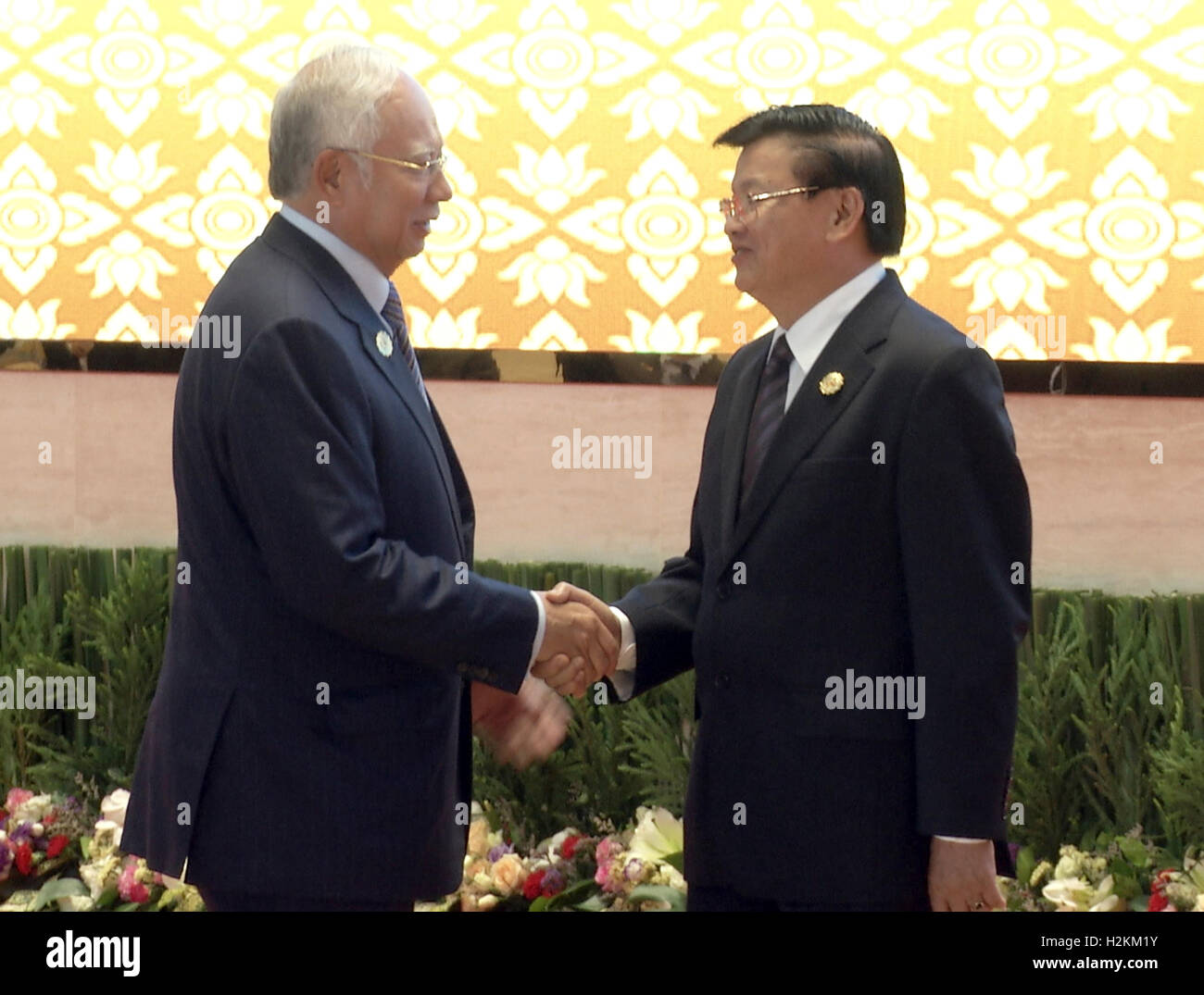Najib Razak is greeted by the Laos Prime Minister Thongloun Sisoulith and wife at the Association of Southeast Asian Nations (ASEAN) summit the Laotian capital Vientiane. Stock Photo