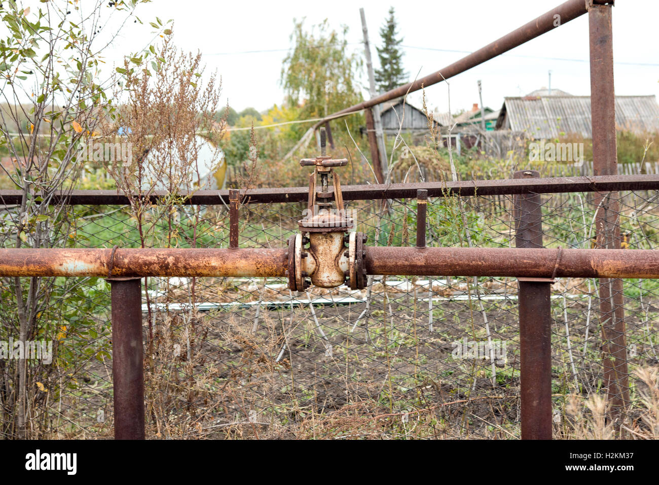 old rusty valve on the of an old rusty pipe Stock Photo