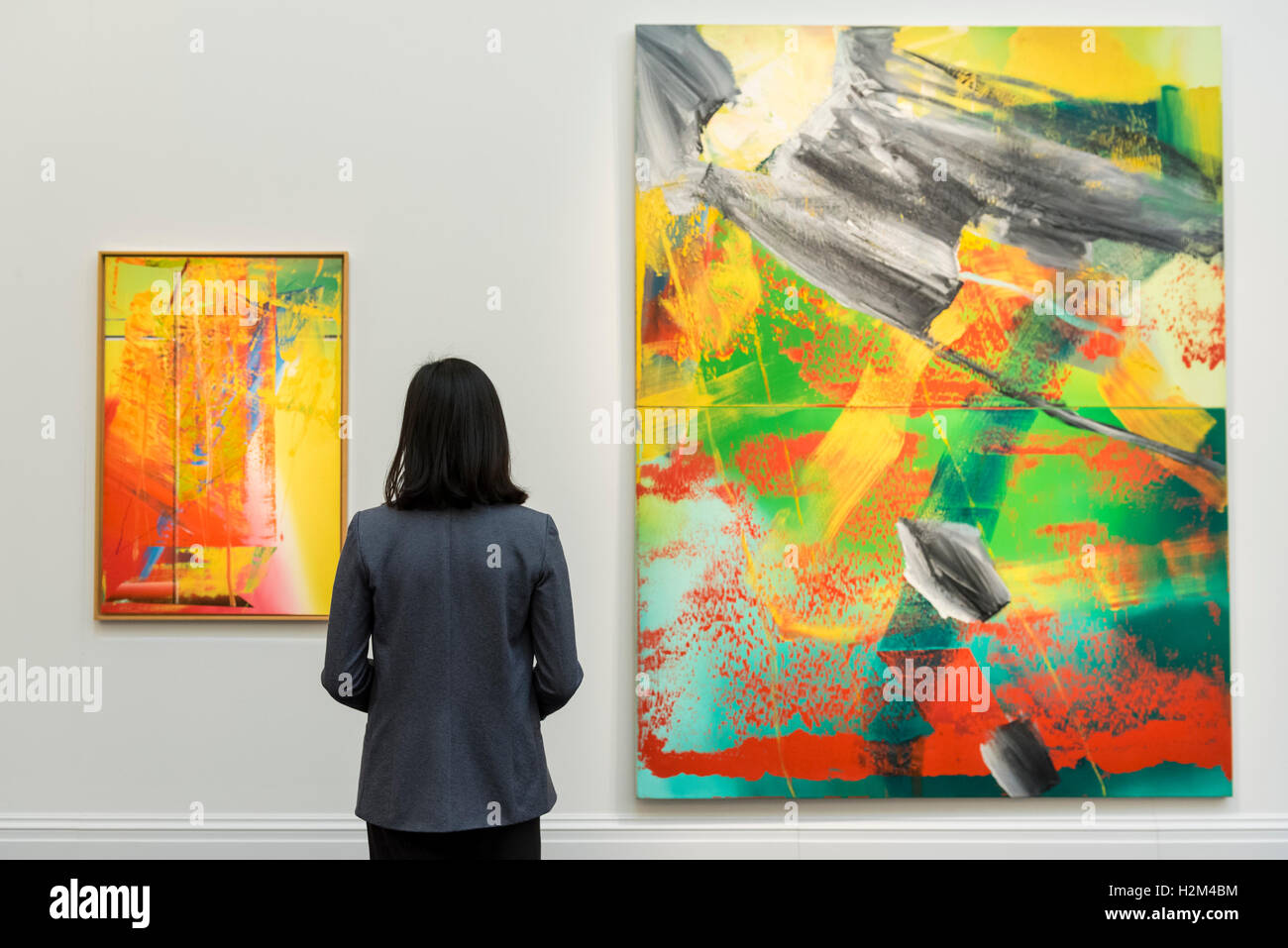 London, UK.  30 September 2016.  (L to R) 'Abstraktes Bild' (est. GBP1-1.5 million) and 'Garten' (est. GBP3-4 million) both by Gerhard Richter are viewed by a staff member at the preview of Sotheby's London upcoming Contemporary Art Auctions.  Credit:  Stephen Chung / Alamy Live News Stock Photo