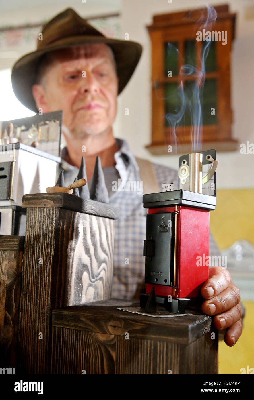 Company owner Jurgen Huss stands in the show of company Huss with an incense oven in