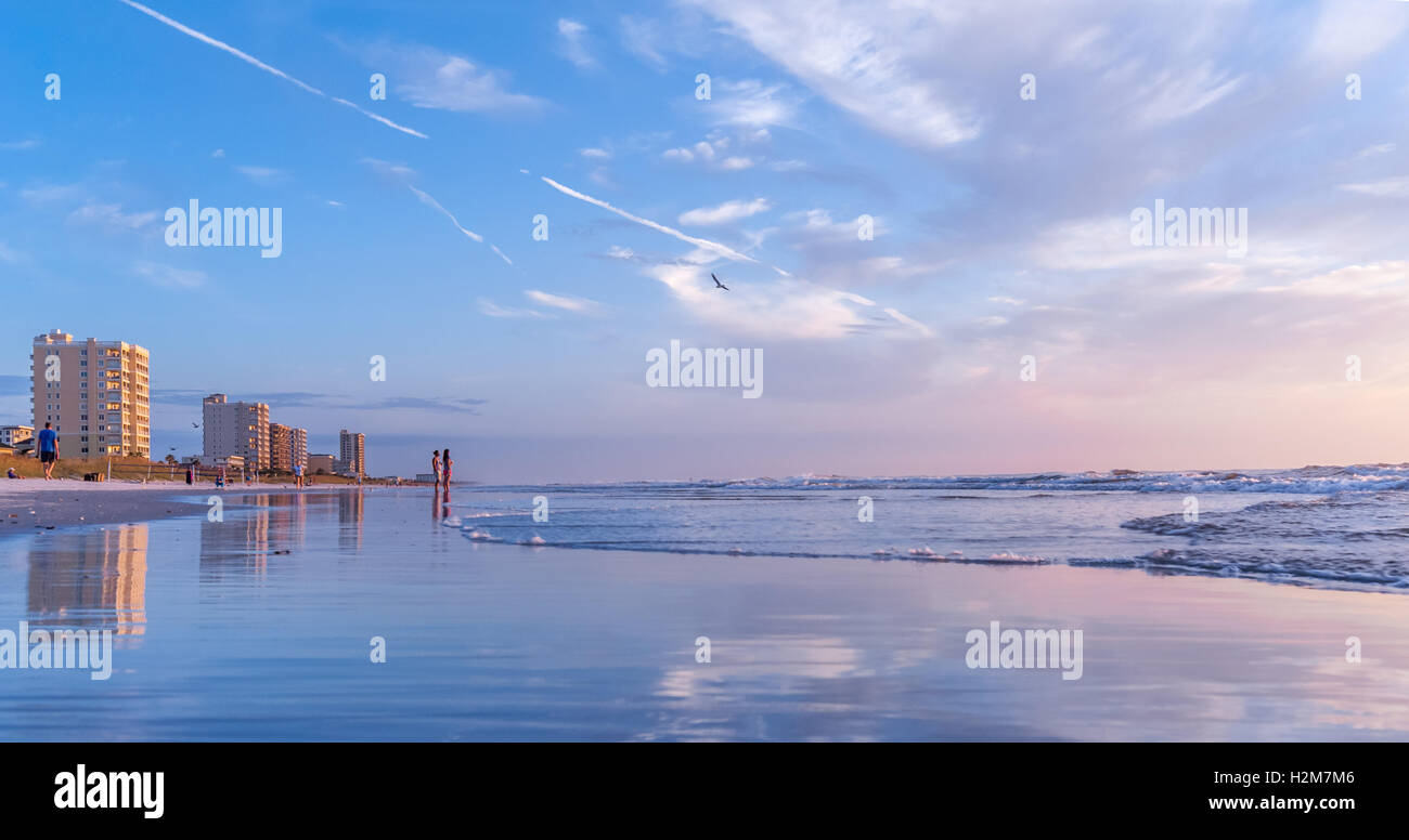 Early risers enjoy the beauty and serenity of sunrise at Jacksonville Beach in Northeast Florida, USA. Stock Photo