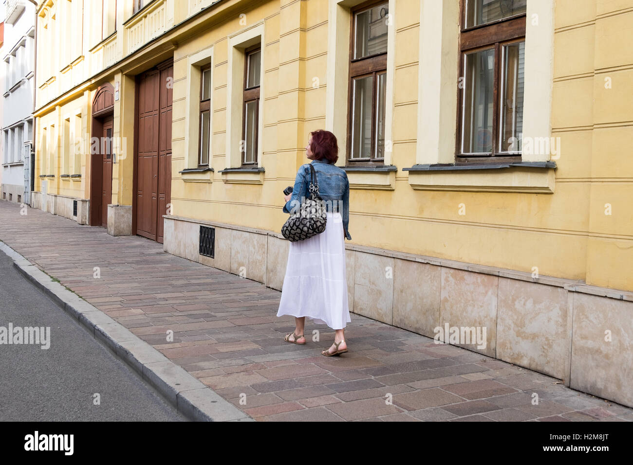 Woman in a dress walking down a street. Stock Photo