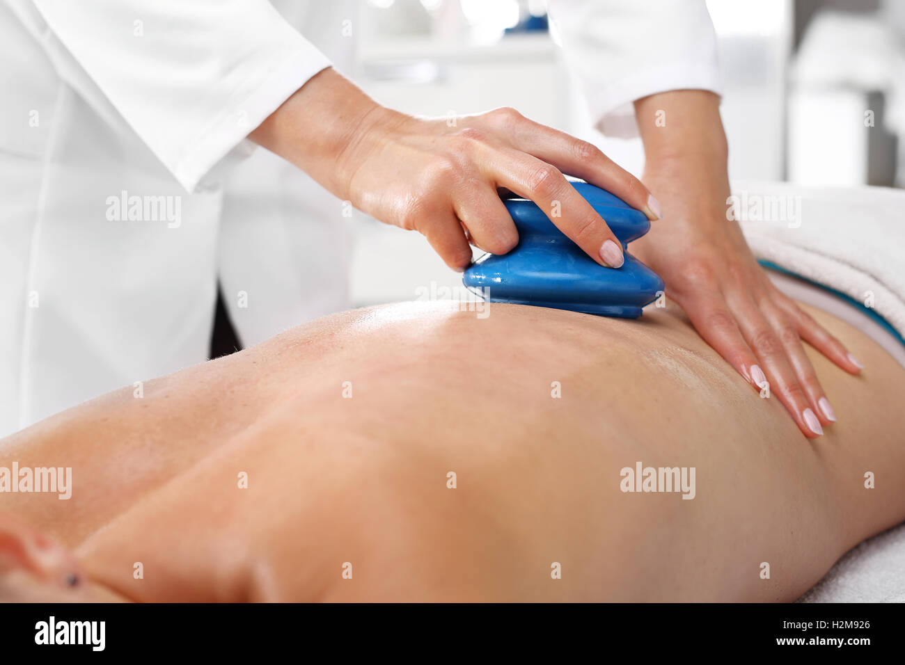 Wellness and spa. Massage. Back massage. Alternative medicine. Massage Masseur massaging her back rubber Chinese bubble. Stock Photo