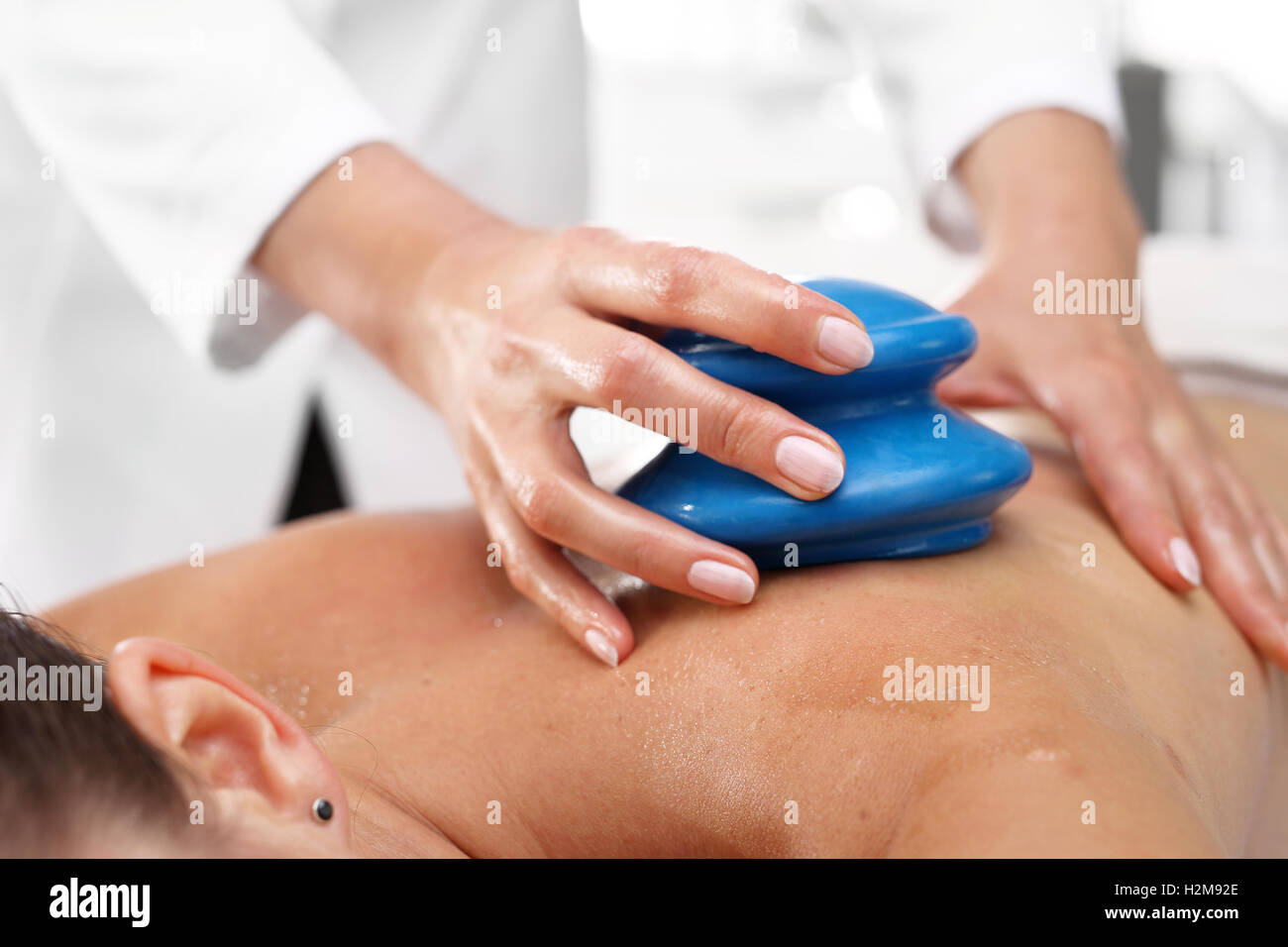 Chinese cupping massage.Alternative medicine. Massage Masseur massaging her back rubber Chinese bubble. Stock Photo