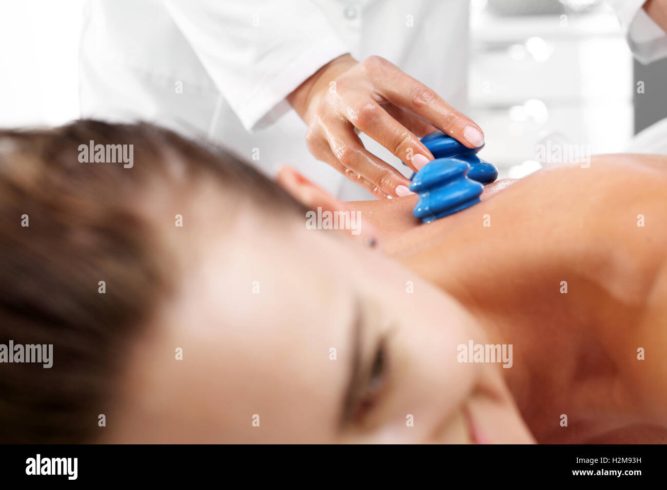 Alternative medicine. Massage Masseur massaging her back rubber Chinese bubble. Stock Photo