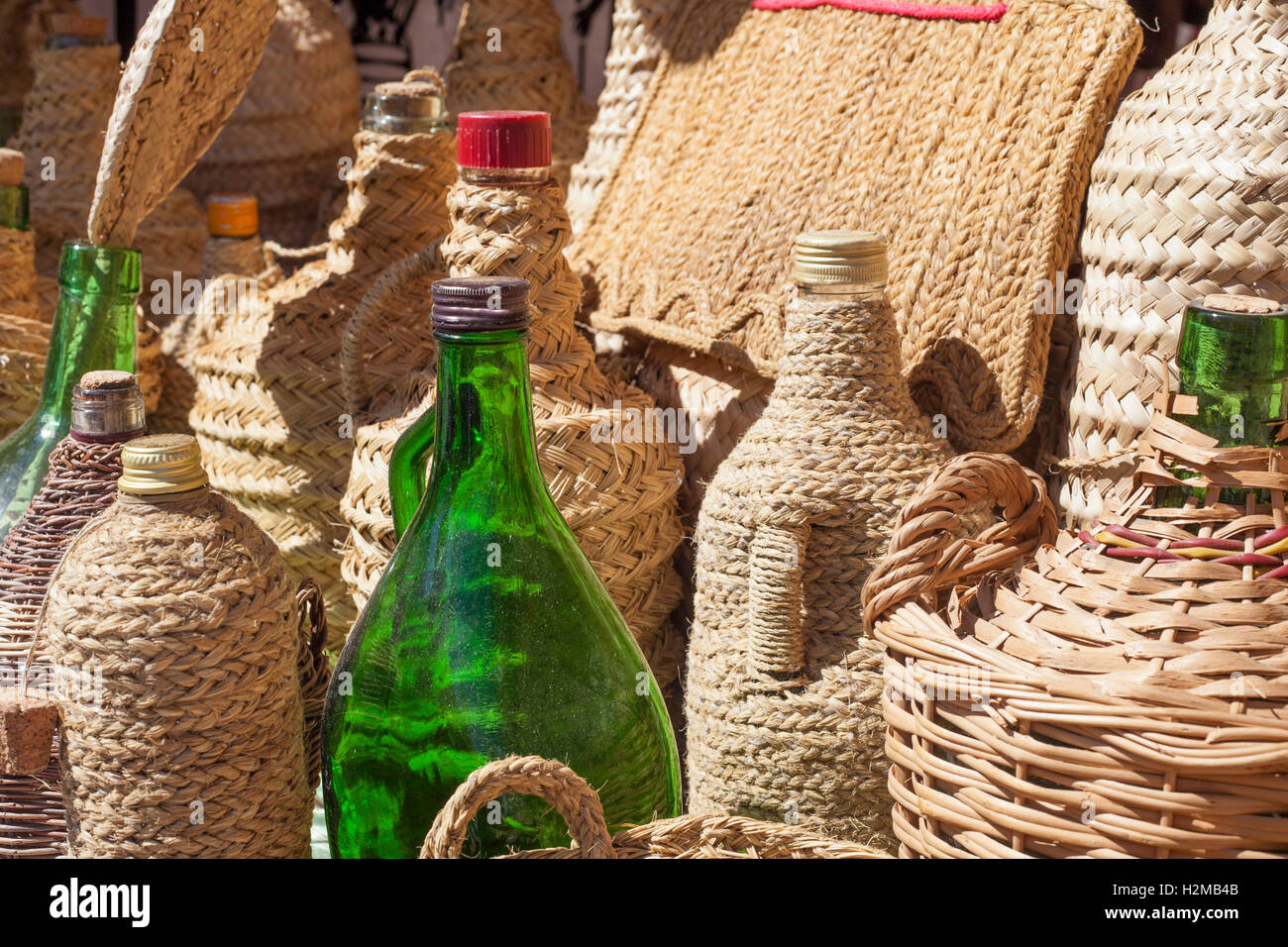 Esparto handcrafts covering recycled glass bottles Stock Photo