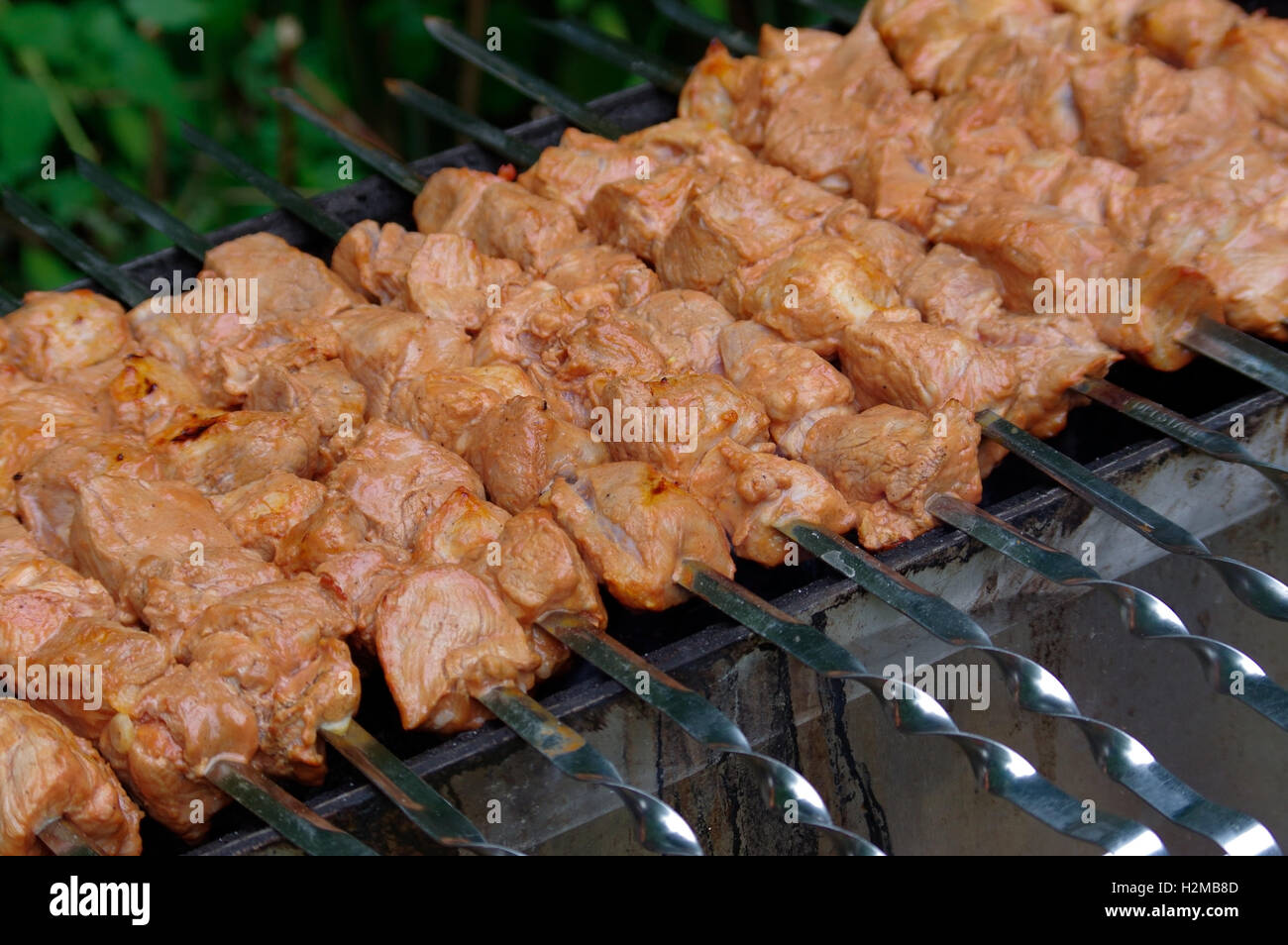 Grilling marinated shashlik on a grill. Shashlik is a form of Shish kebab  popular in Eastern, Central Europe and other places. Shashlyk meaning skewer  Stock Photo - Alamy