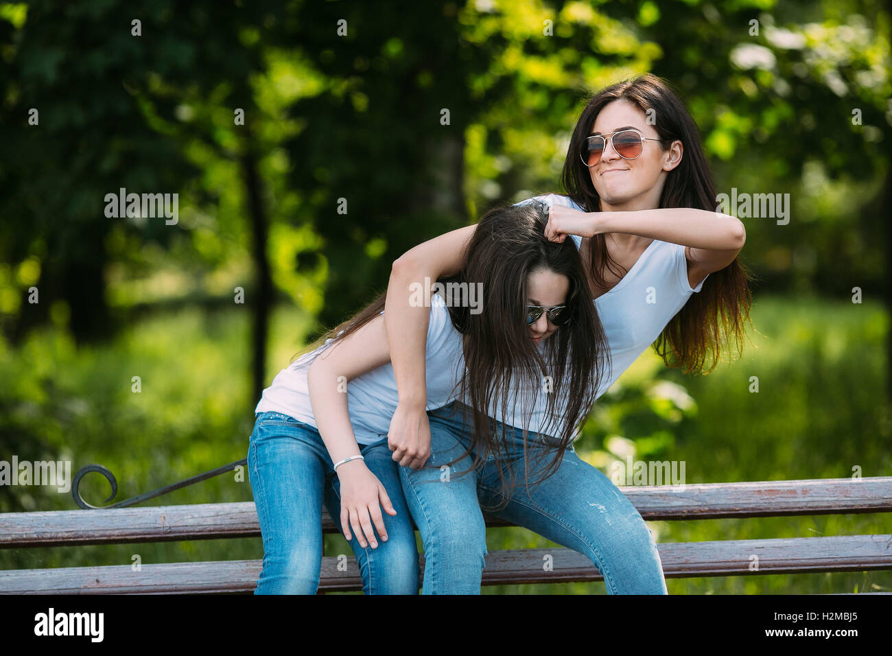 Mother and daughter sitting on a bench in the park Stock Photo - Alamy