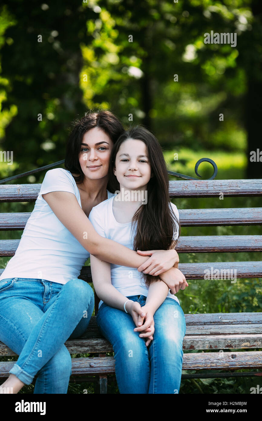 Mother and daughter sitting on a bench in the park Stock Photo - Alamy