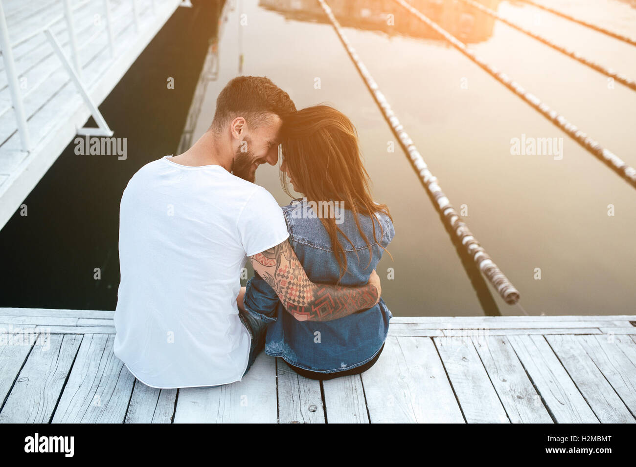 beautiful couple posing on a wooden pier at lake Stock Photo - Alamy