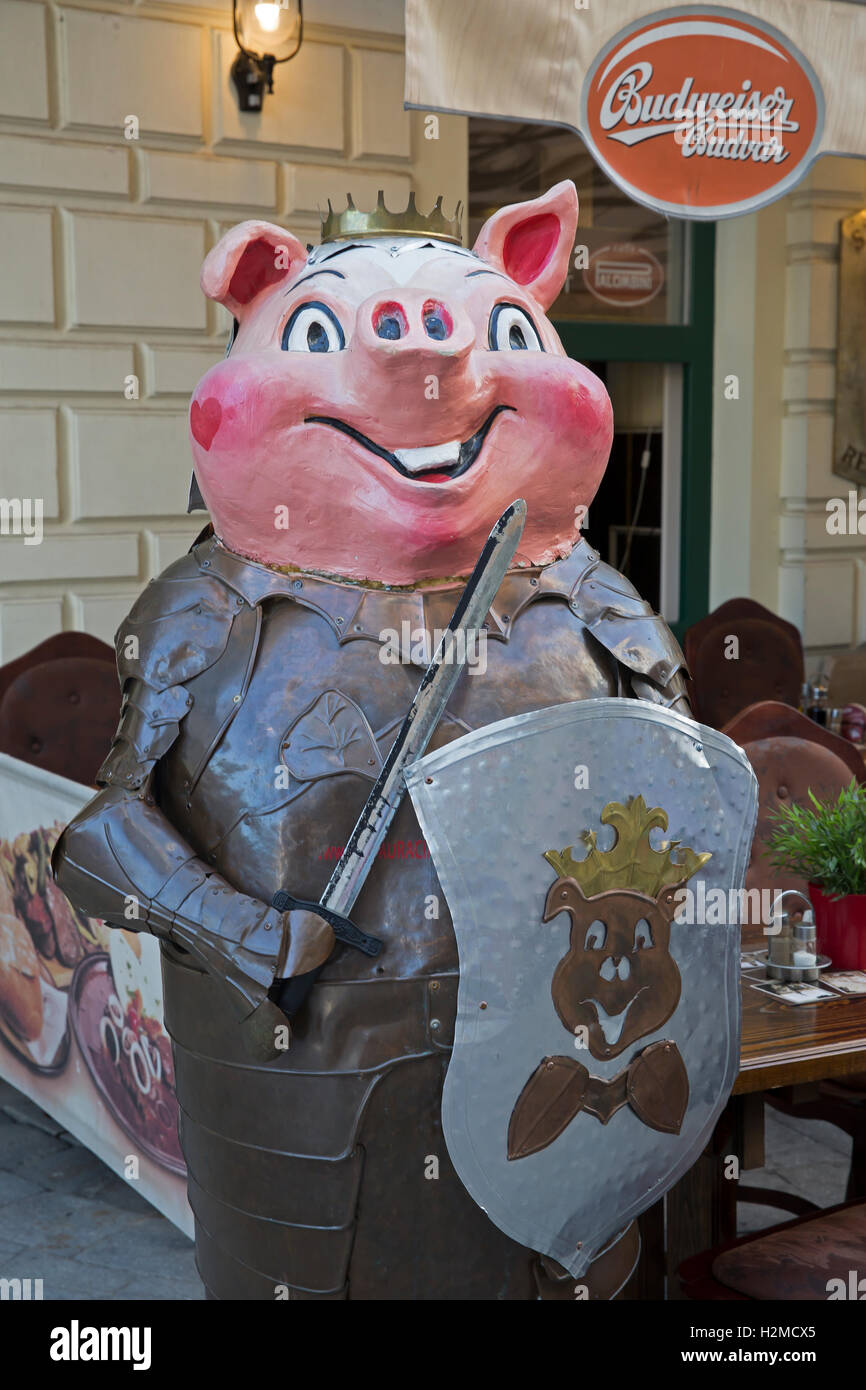 Pig statue in armour with a sword and shield outside a restaurant in