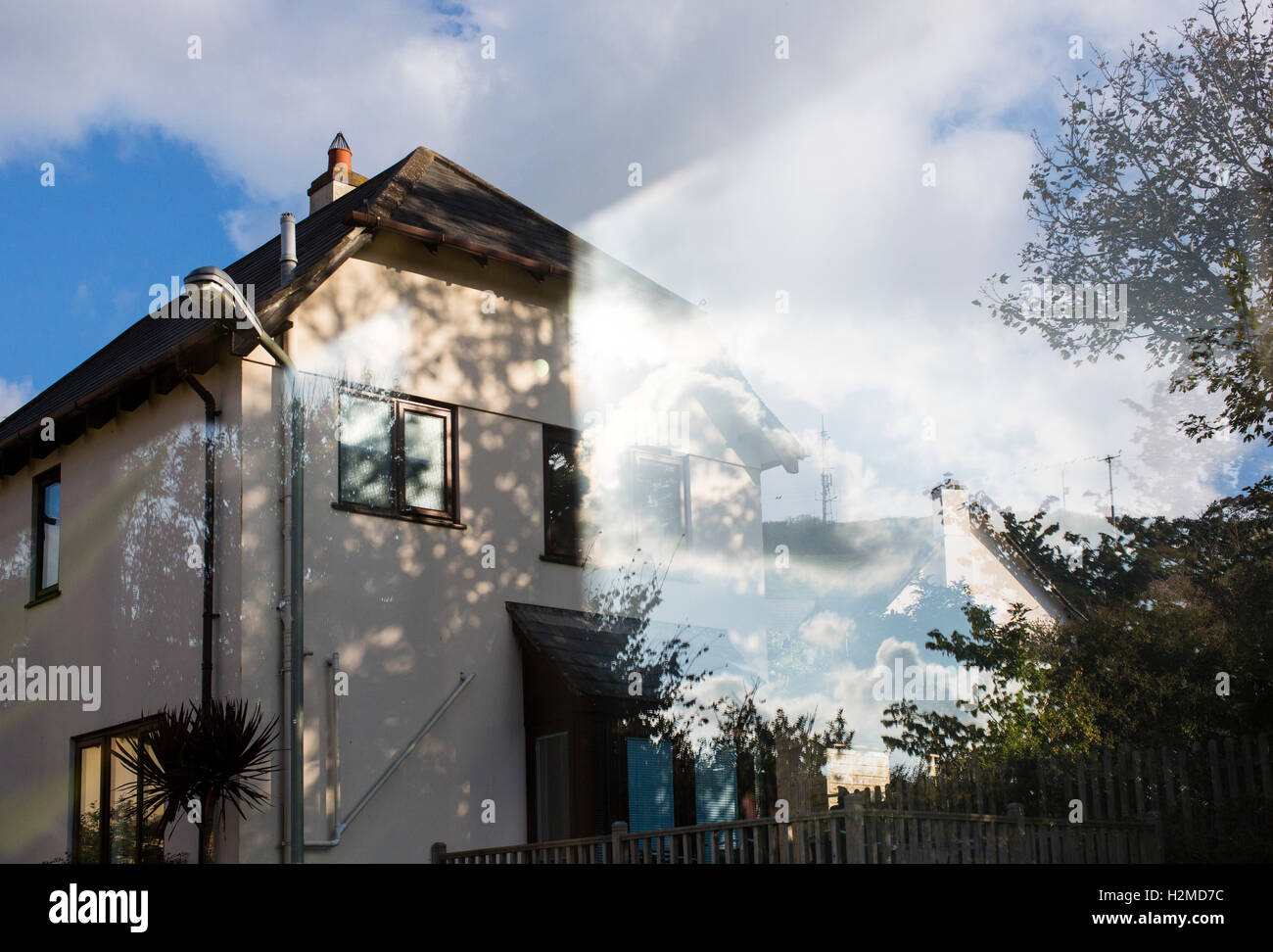 Reflections on a window looking from the inside to the outside on a UK housing estate. Stock Photo