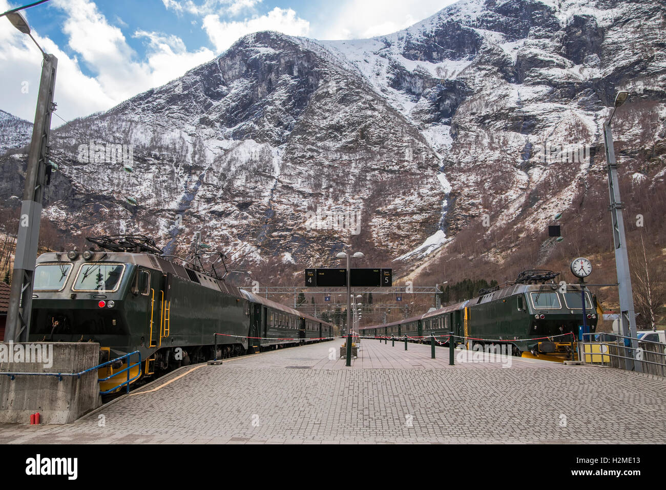 Platform with two trains and high mountains in the background. Norway Stock Photo