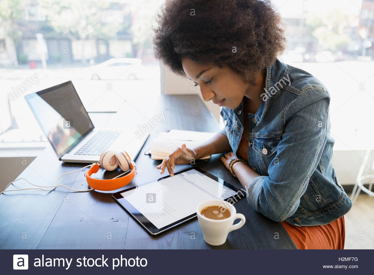 Focused woman working at digital tablet in cafe Stock Photo
