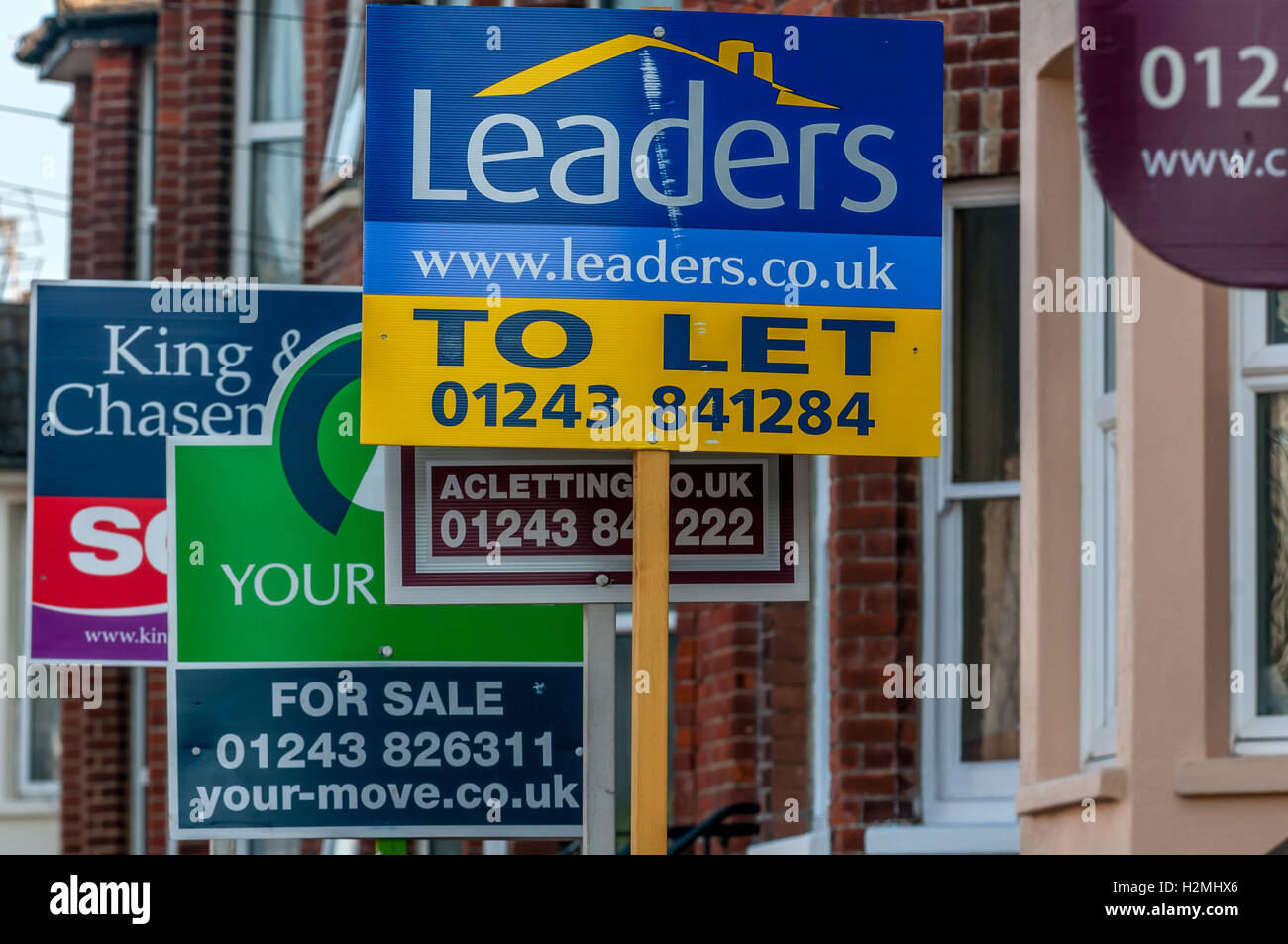 Estate agent boards decorating a street in Littlehampton Stock Photo