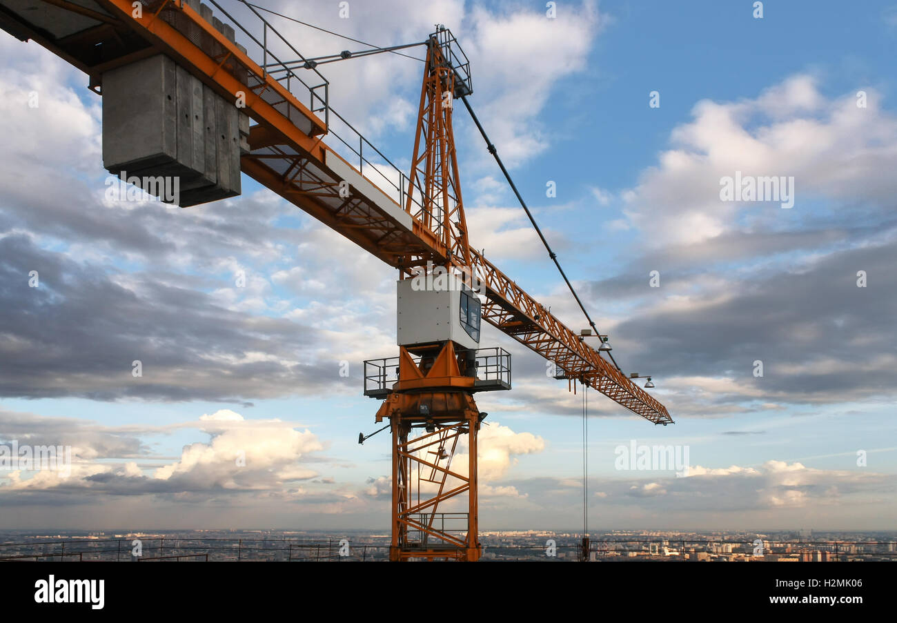 Industrial construction crane against the backdrop of a cloudy sky ...