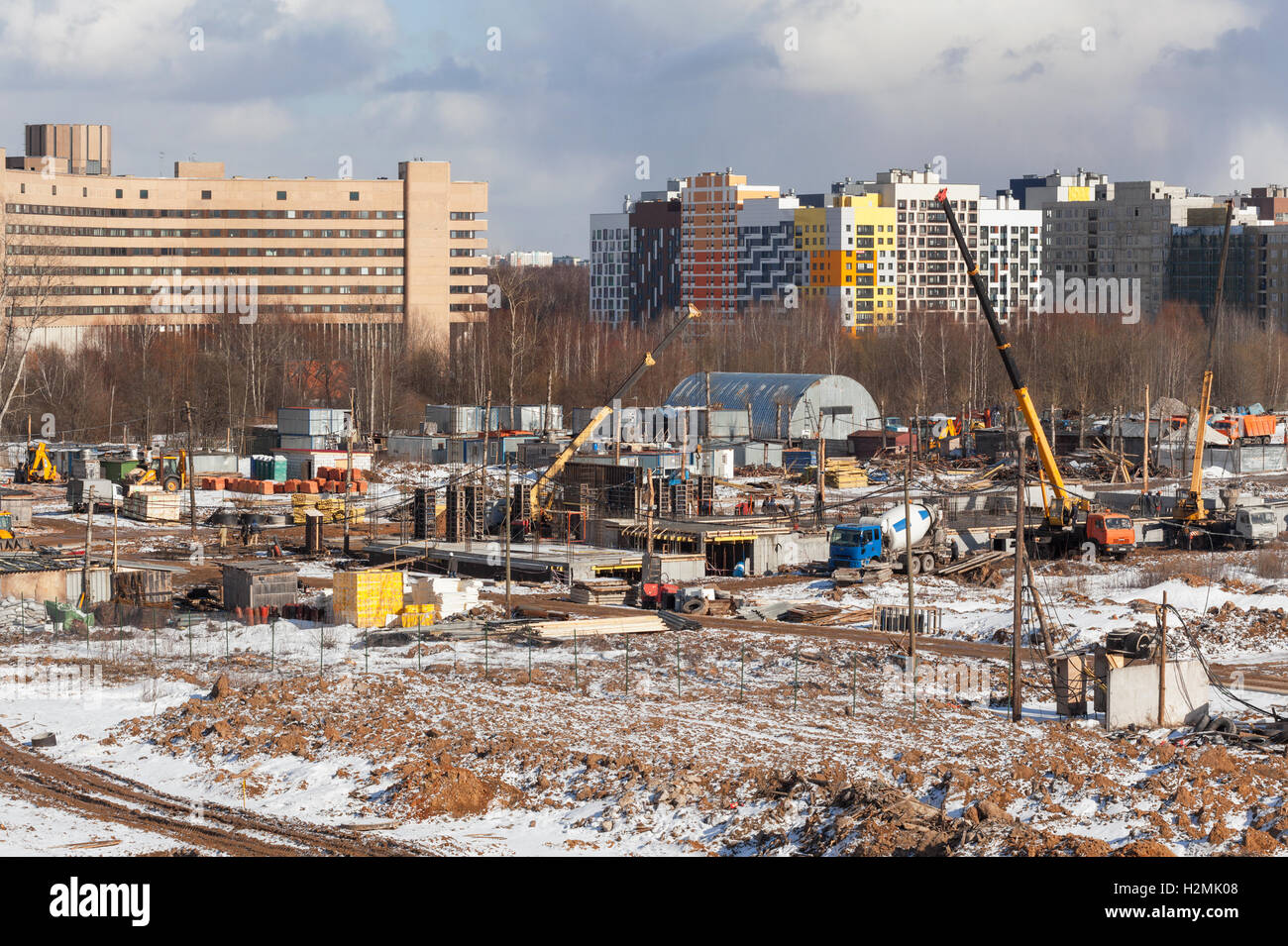 The construction site of the future apartment house in the winter against the backdrop of modern buildings Stock Photo