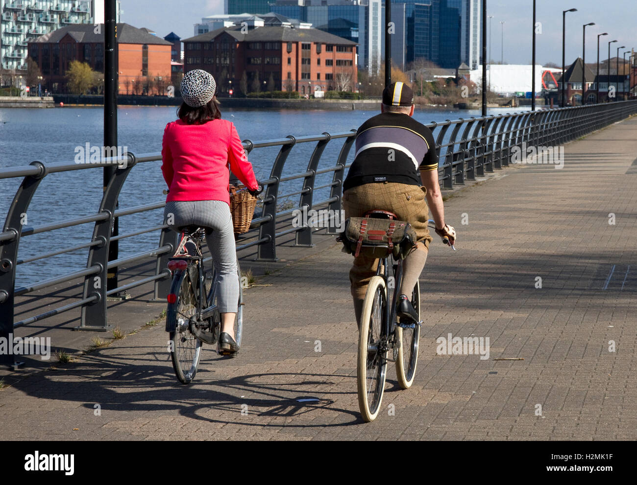 Cyclists ( vintage style) riding along Trafford Wharf , Salford Quays, Salford / Manchester, UK Stock Photo