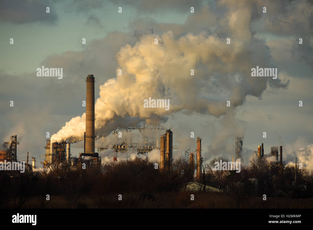 Heavy smoke being released from smokestacks in late afternoon Stock Photo