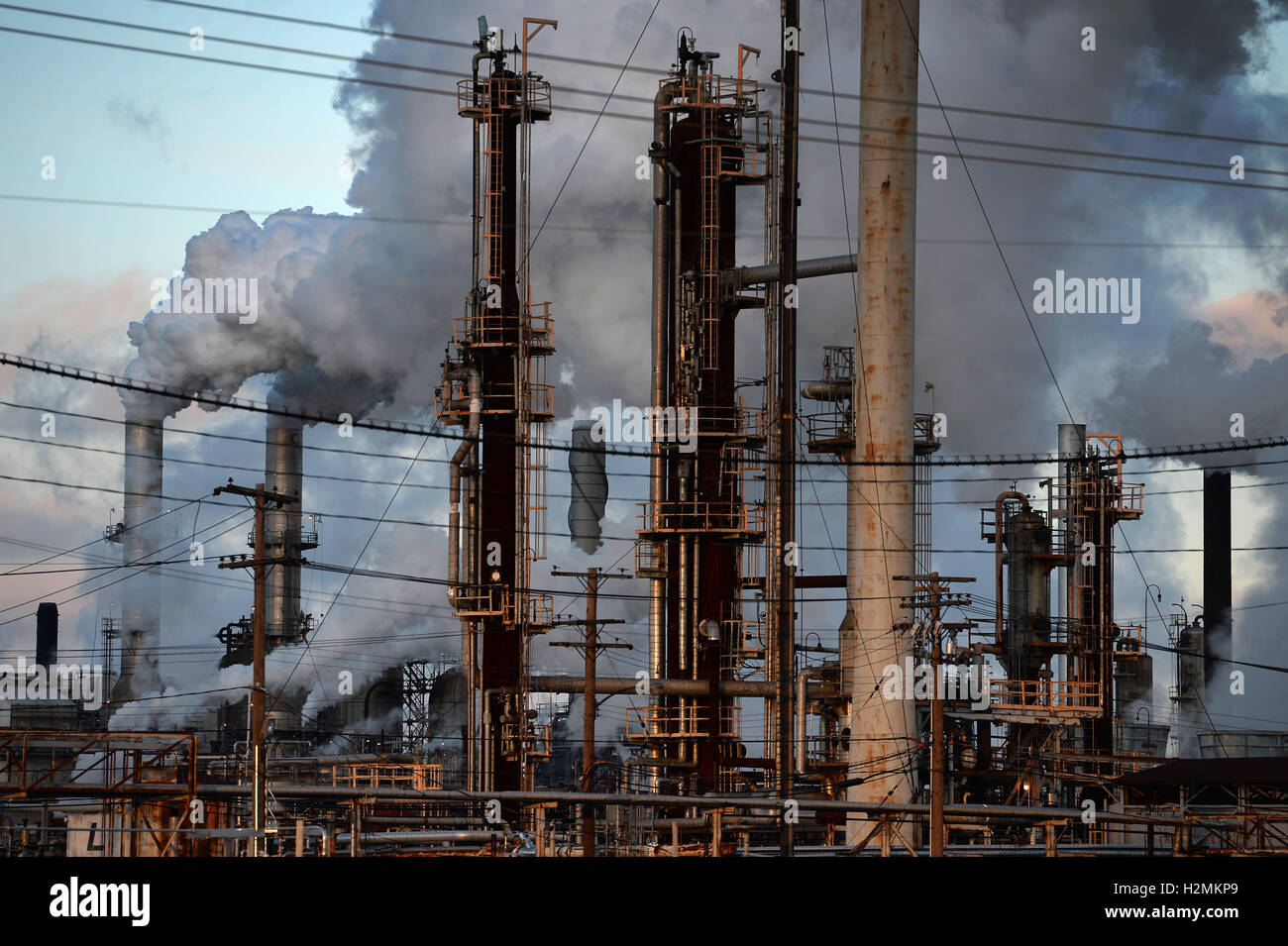 Thick smoke coming out of smokestacks from oil refinery Stock Photo