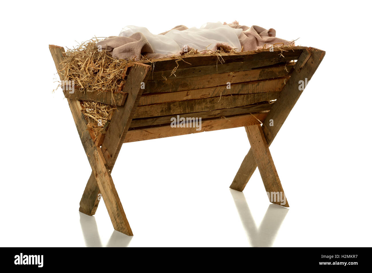 Manger with hay and fabrics isolated over white background Stock Photo