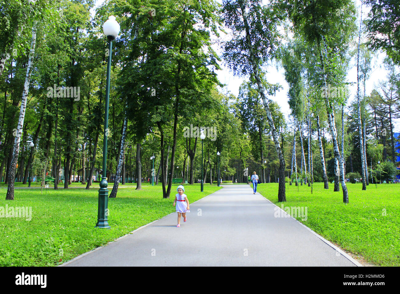 baby walks alone on the footpath in the city park with big trees Stock  Photo - Alamy