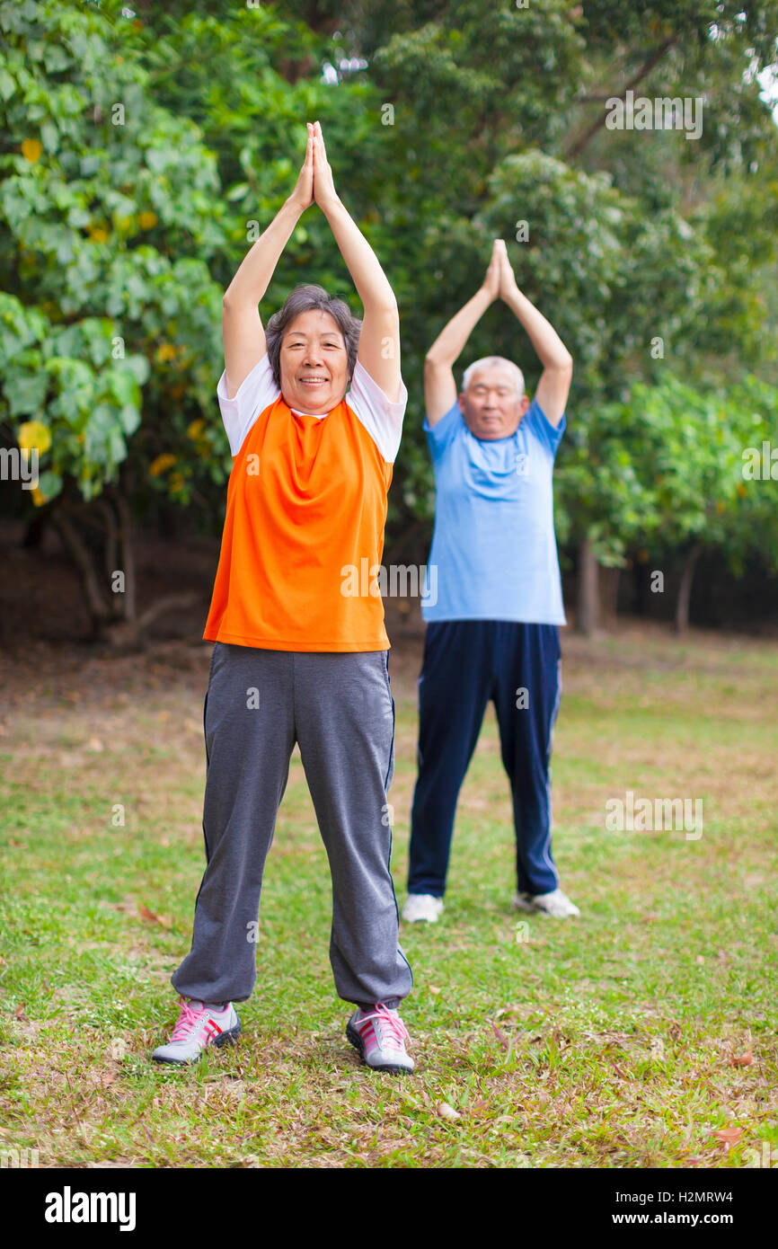 Senior couple doing exercise in the park Stock Photo - Alamy