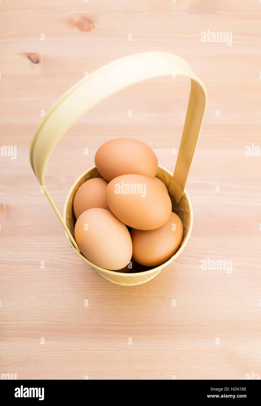 Brown egg in bucket with wooden background Stock Photo