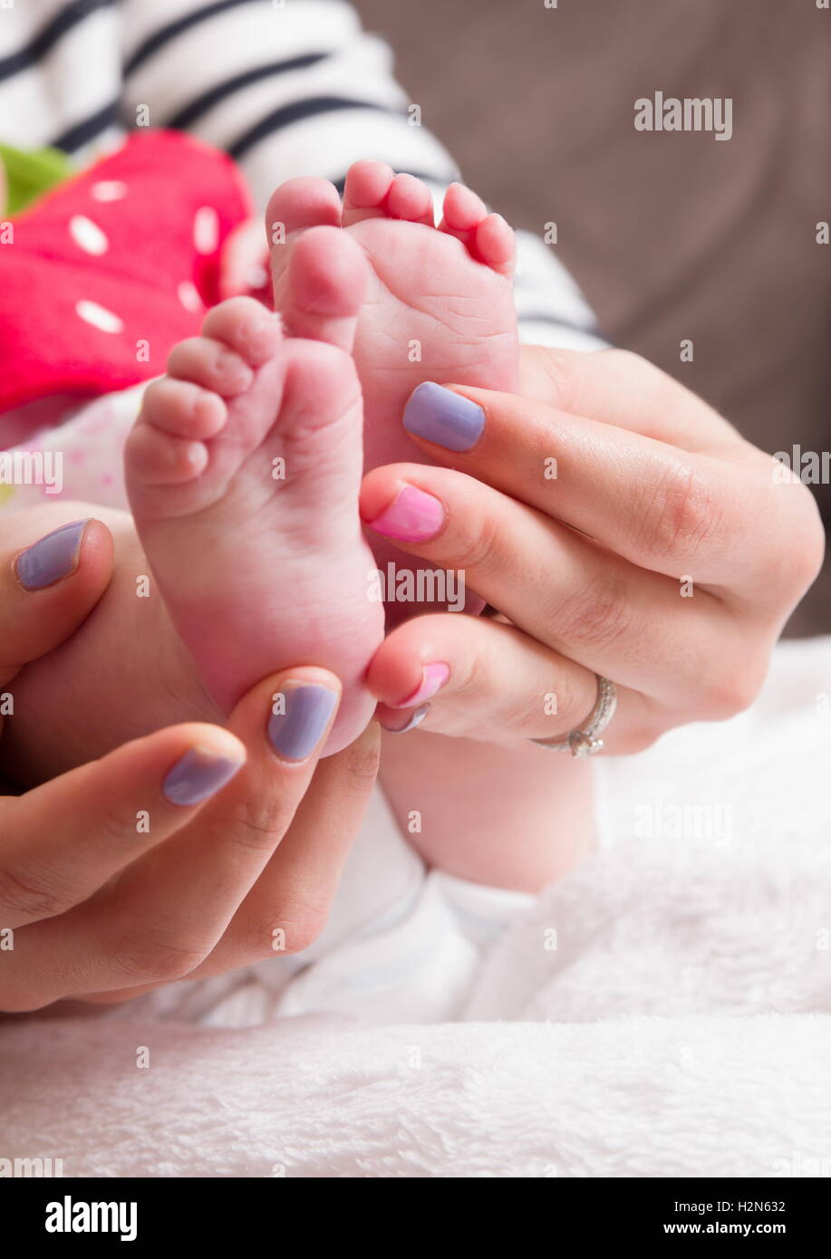 small baby legs in mother hands Stock Photo