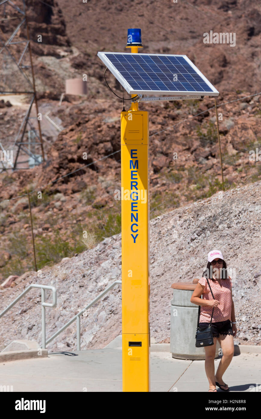 Boulder City, Nevada - A woman walks past a solar-powered emergency call box near the Hoover Dam. Stock Photo