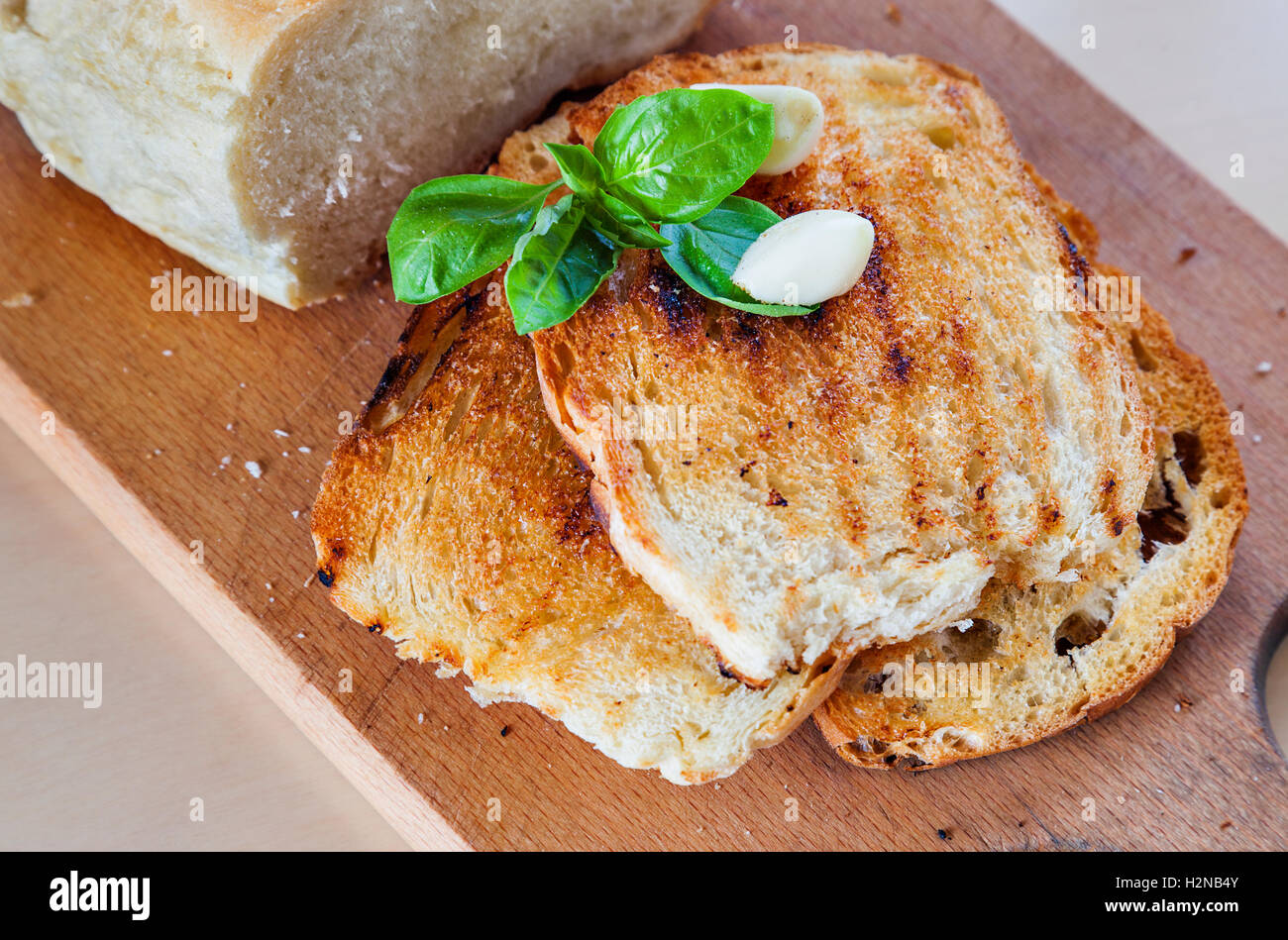Three roasted slices of bread with garlic, fresh basil and a bread on