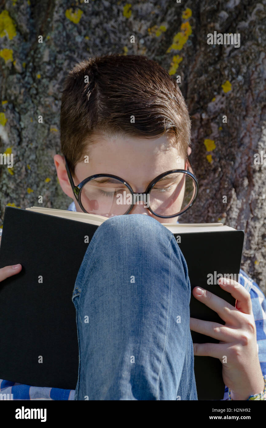 Shallow Reading Young boy reading a book in the woods with shallow depth of fiel Stock ...