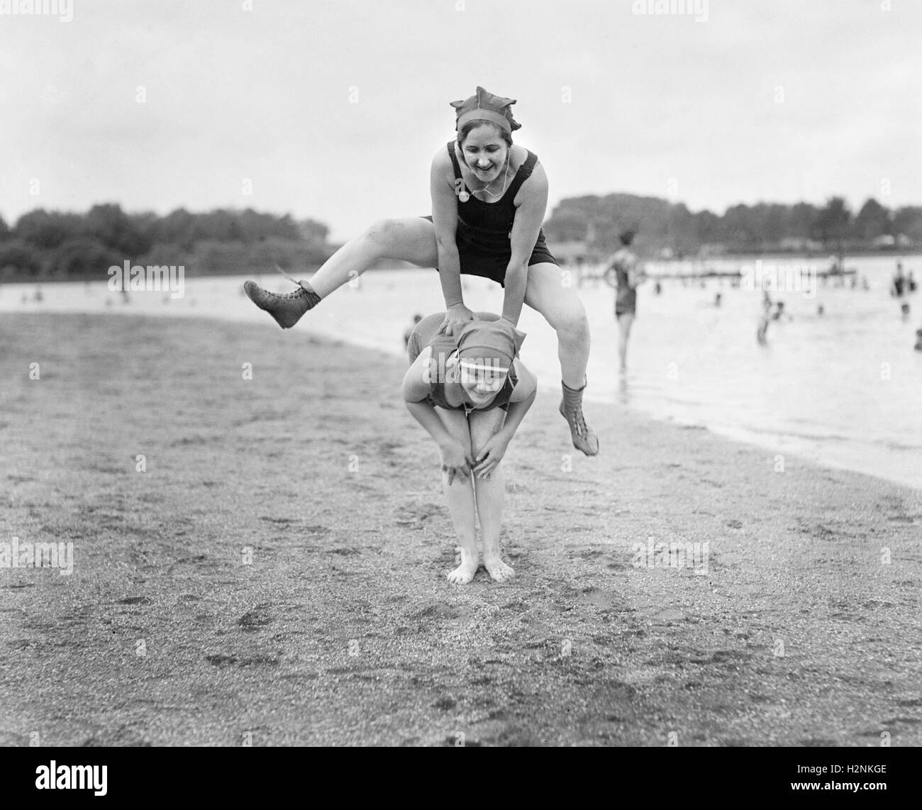 Two Young Women Playing Leap Frog on Beach, USA, National Photo Company, 1921 Stock Photo