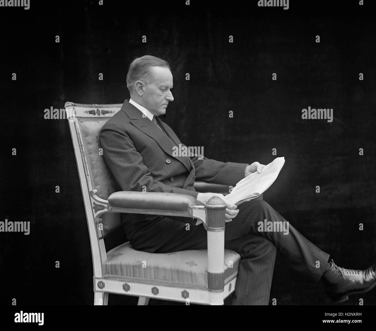 U.S. President Calvin Coolidge, Portrait Reading Newspaper, Washington DC, USA, National Photo Company, May 1924 Stock Photo