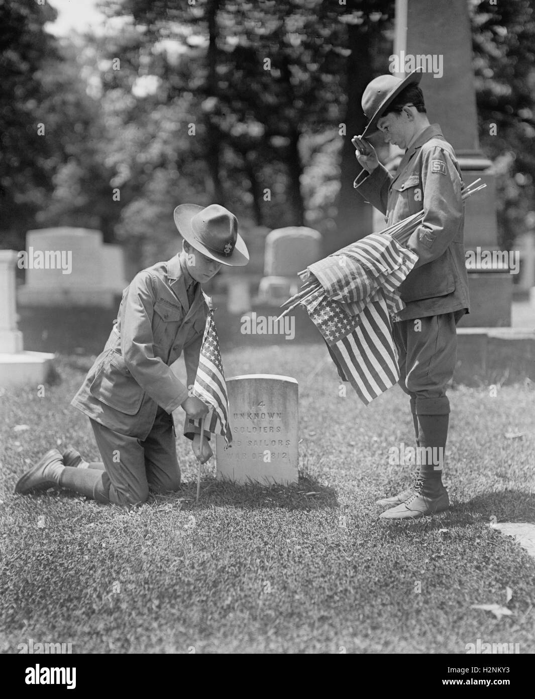 Two Boy Scouts putting American Flags at Grave of 14 Unknown Soldiers and Sailors from War of 1812, Arlington National Cemetery, Arlington, Virginia, USA, National Photo Company, May 1925 Stock Photo