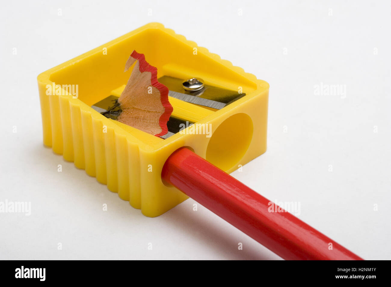 Red pencil and yellow pencil sharpener on a white background Stock Photo
