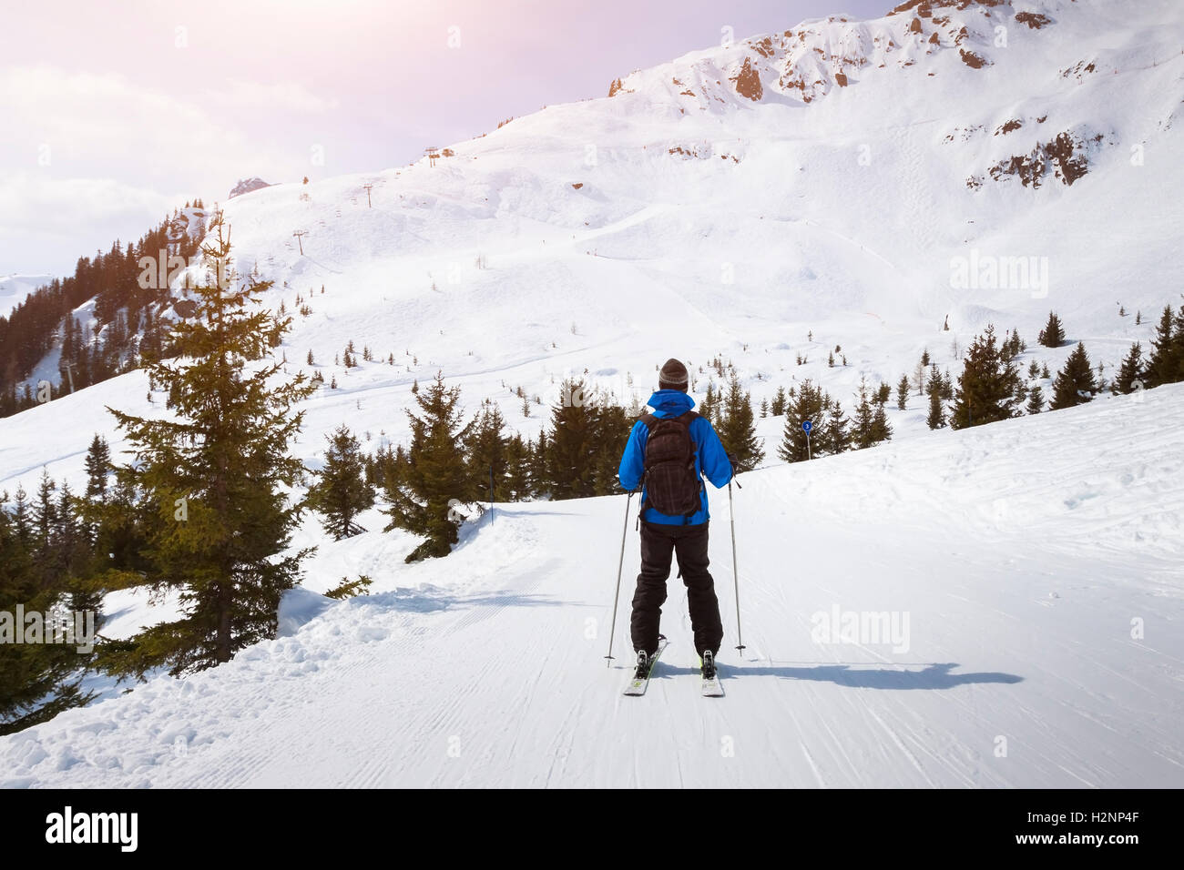 Skier skiing on easy blue trail with beautiful landscape in background Stock Photo