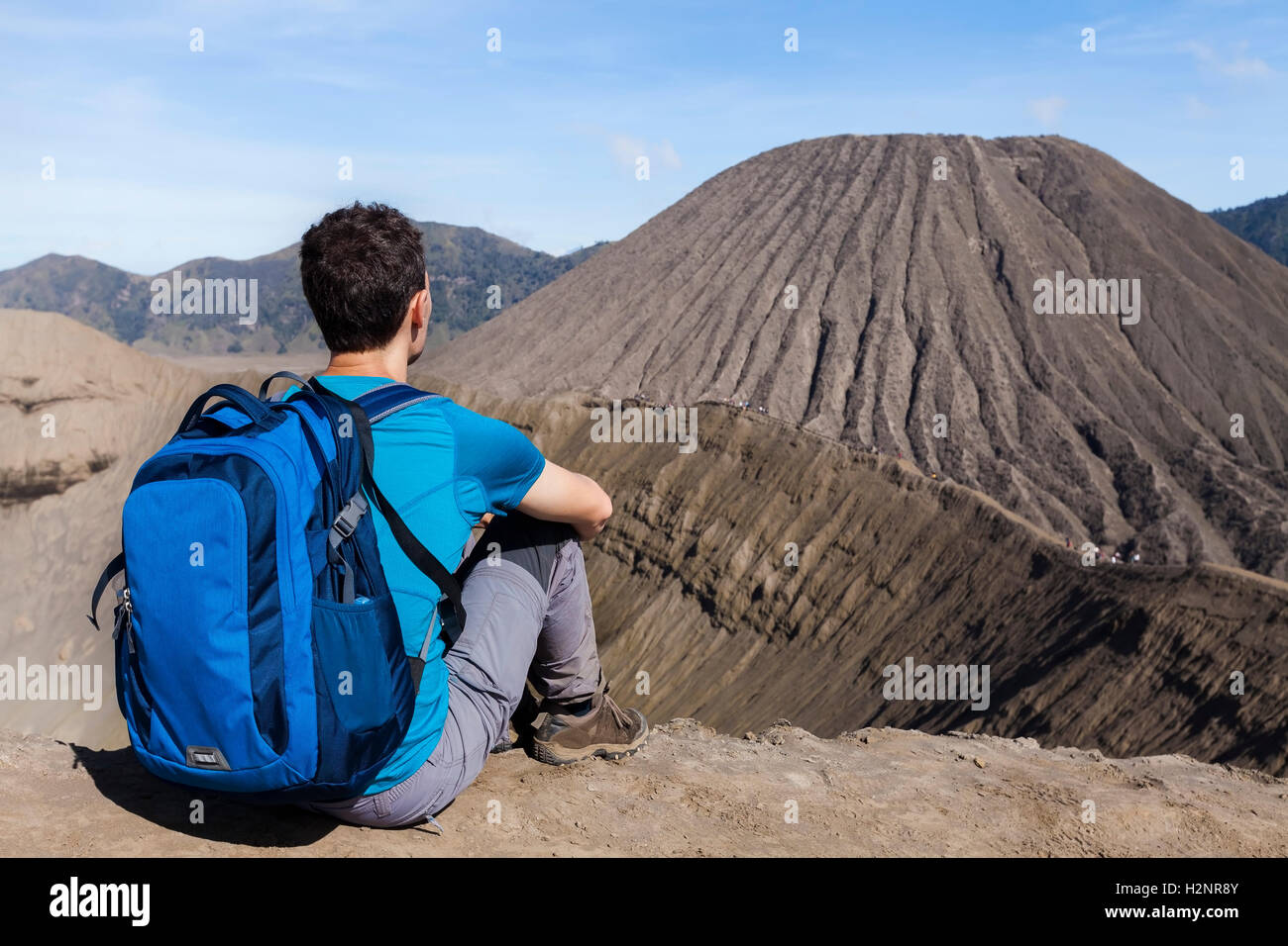 Young male adult traveler watching the crater and the caldera of the active Bromo volcano, East Java, Indonesia Stock Photo