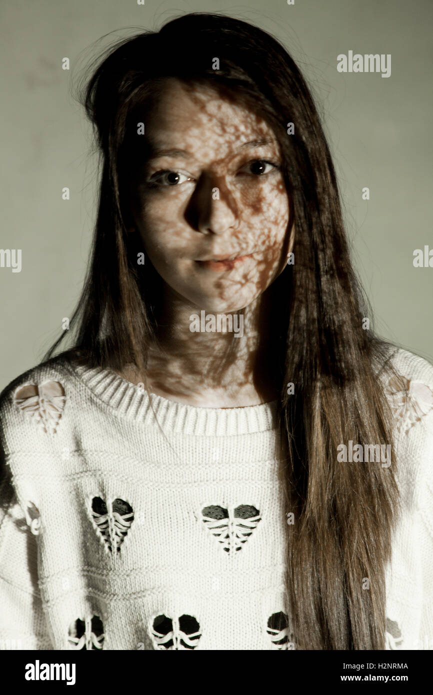 Angharad Barrett modelling with shadowed fabrics highlighting the face. Stock Photo
