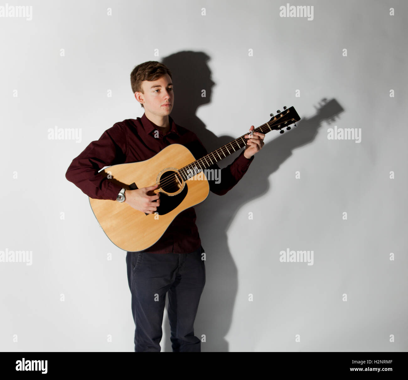 Joel Young in studio holding a guitar with a drop shadow behind. Inspired by Jake Bugg's album cover. Stock Photo