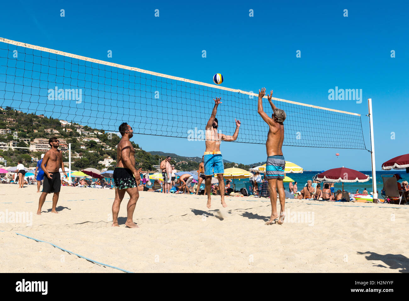 Holidaymakers play beach volleyball, Le Lavandou area, Provence-Alpes-Côte d'Azur region, France Stock Photo