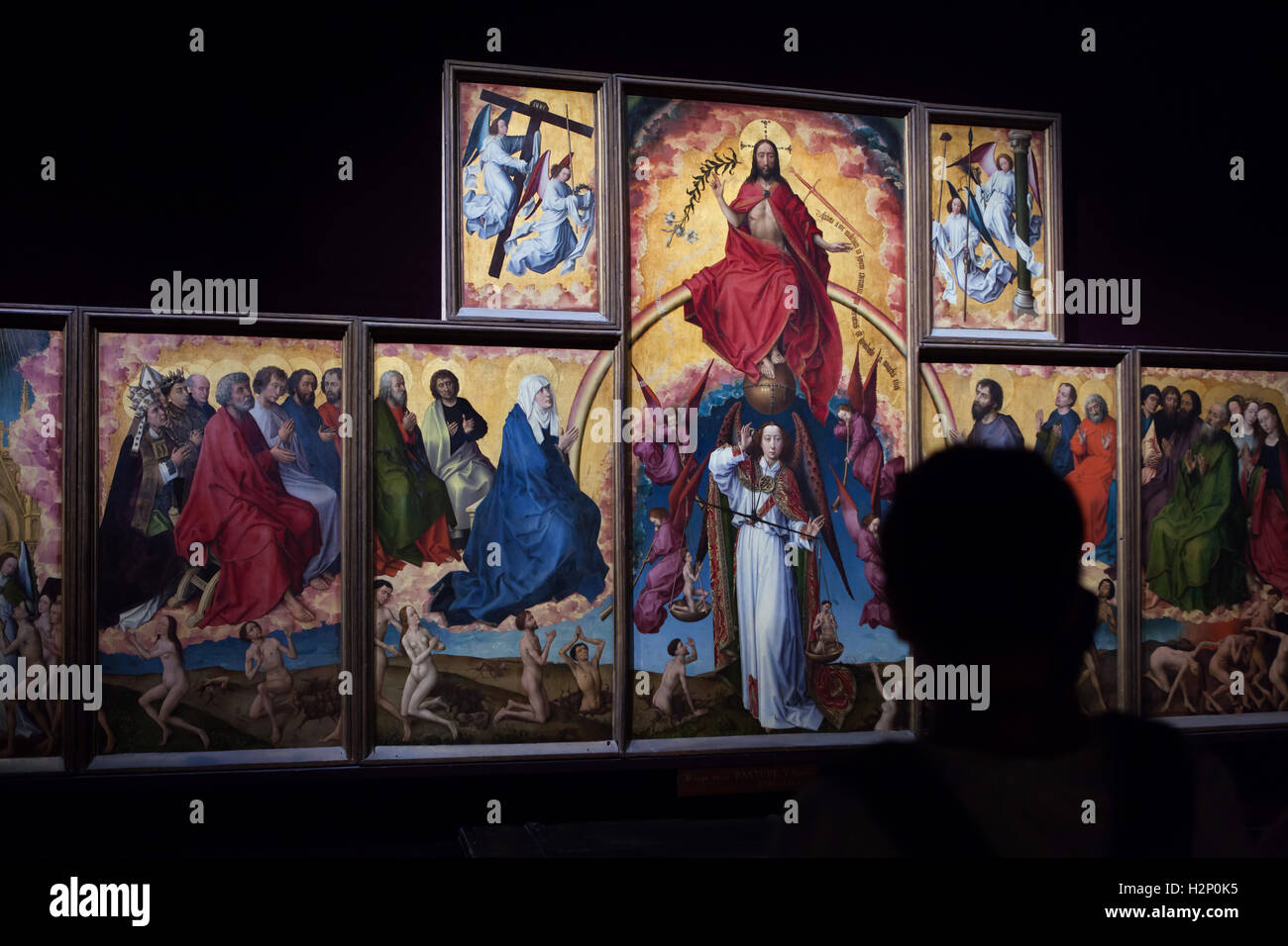 Visitor looks at the Last Judgment Altarpiece by Rogier van der Weyden in the Hotel-Dieu Museum in Beaune, Burgundy, France. Stock Photo
