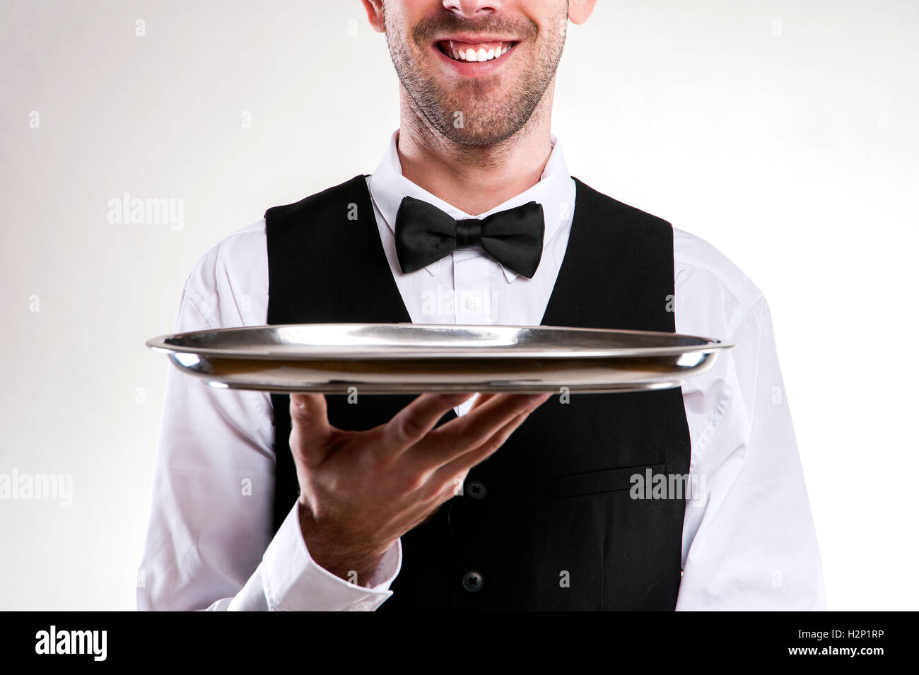 Waiter holding tray. Smiling butler. Stock Photo