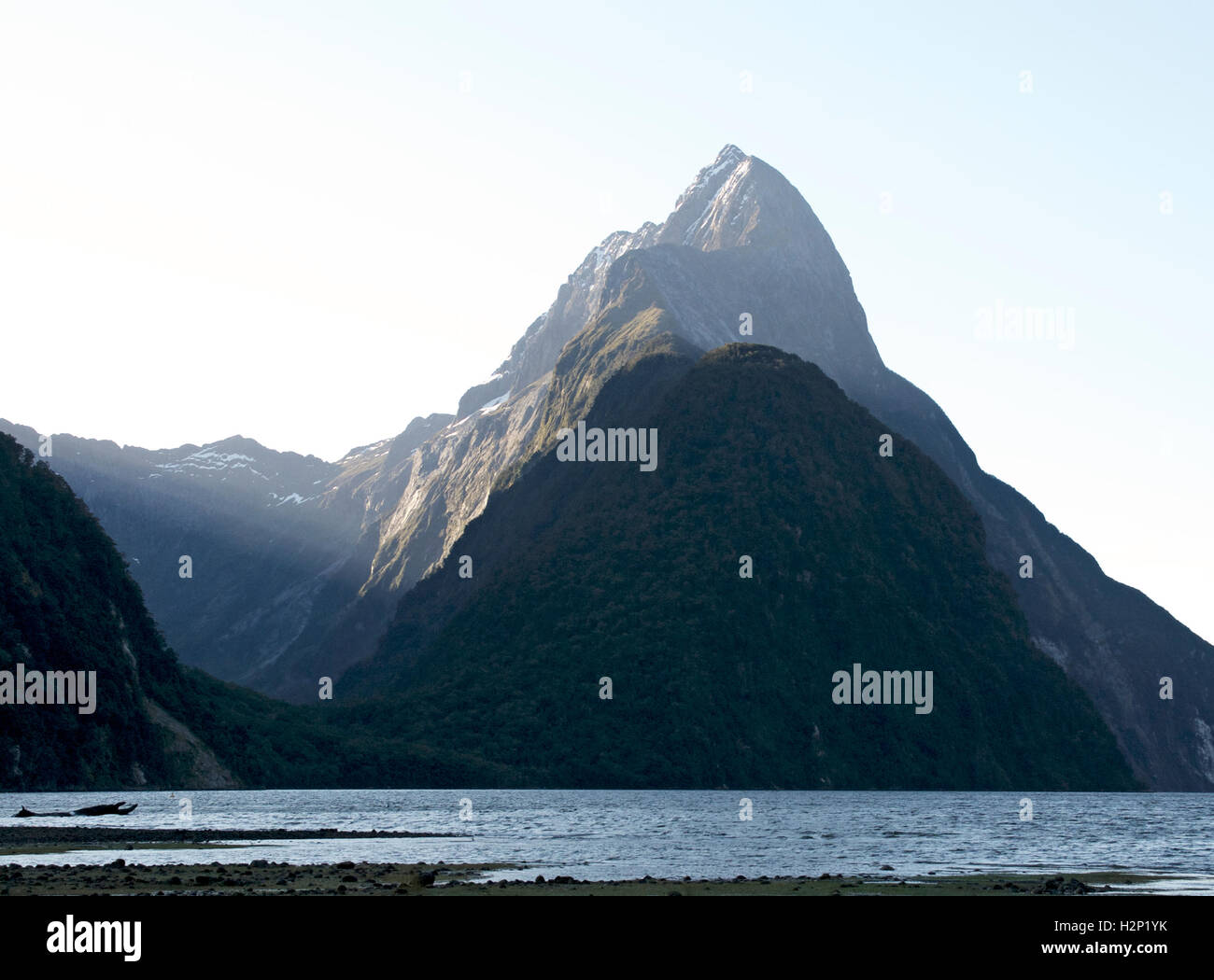 The early morning sun's rays shine on Mitre Peak at Milford Sound, New Zealand. Stock Photo