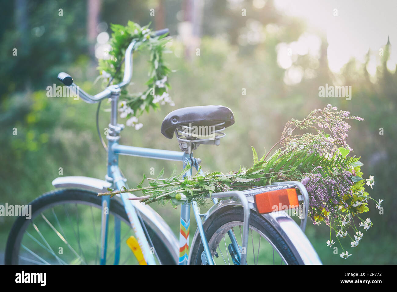 Flowers and garland on bicycle in garden Stock Photo Alamy