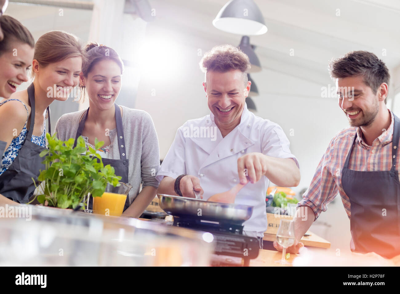 Students watching teacher in cooking class kitchen Stock Photo