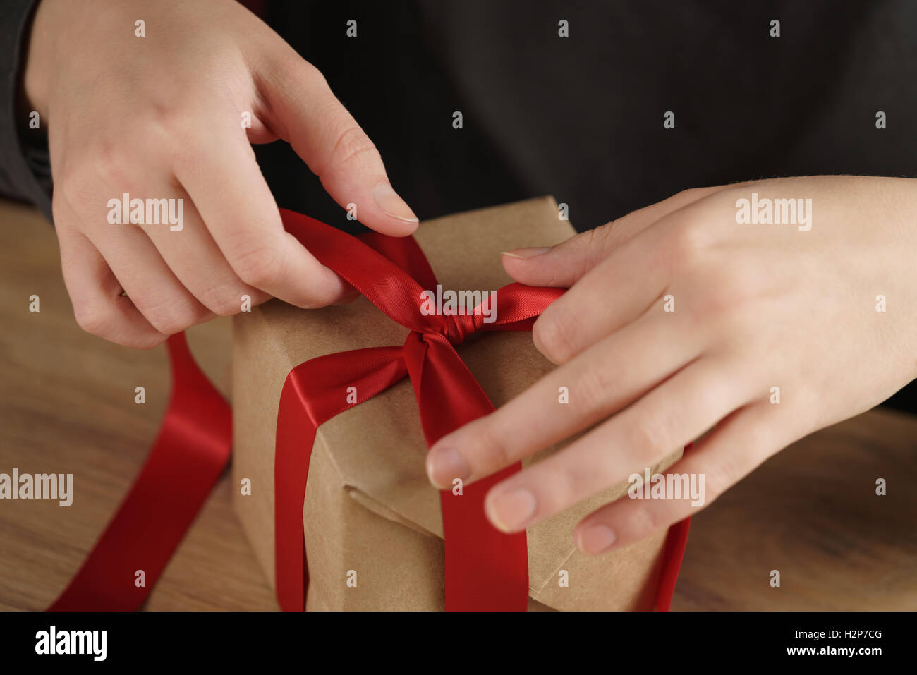 packing presents with red ribbon Stock Photo - Alamy