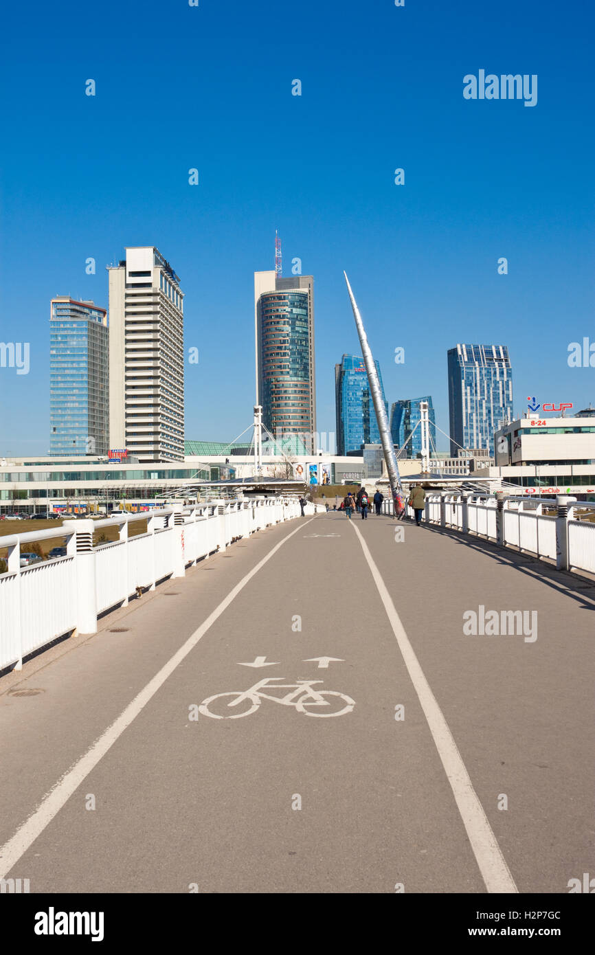 Vilnius, Lithuania - March 16, 2015: White bridge - pedestrian and bicycle bridge across Neris river, modern buildings. Stock Photo