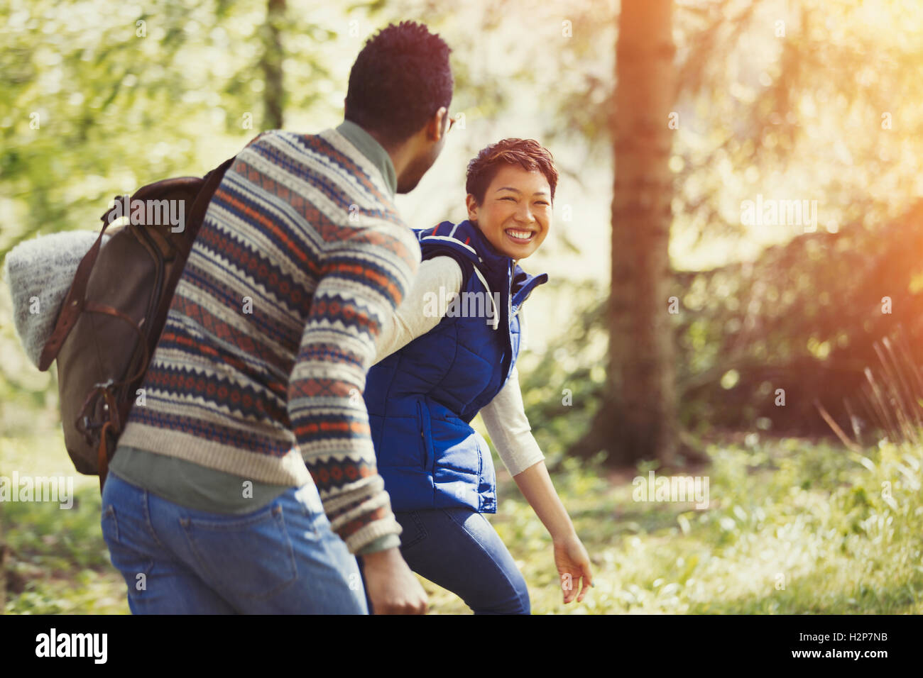 Laughing couple hiking with backpack in woods Stock Photo